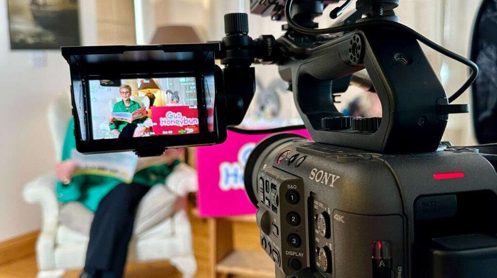 CHSW Gus Rear view of a video camera with its monitor in the background showing what is being filmed but out of focus